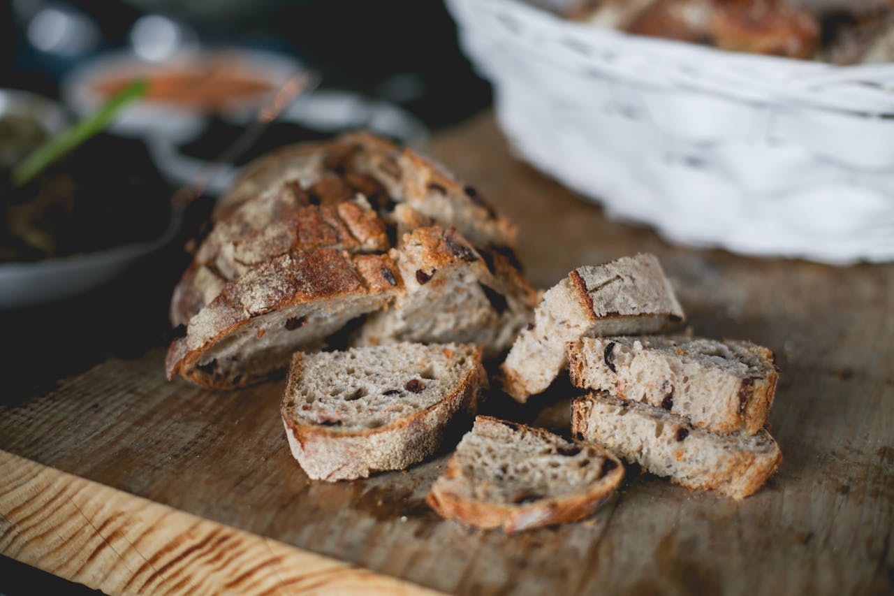 Home Close-up of freshly sliced artisan bread on a rustic wooden board, perfect for breakfast or snacks.