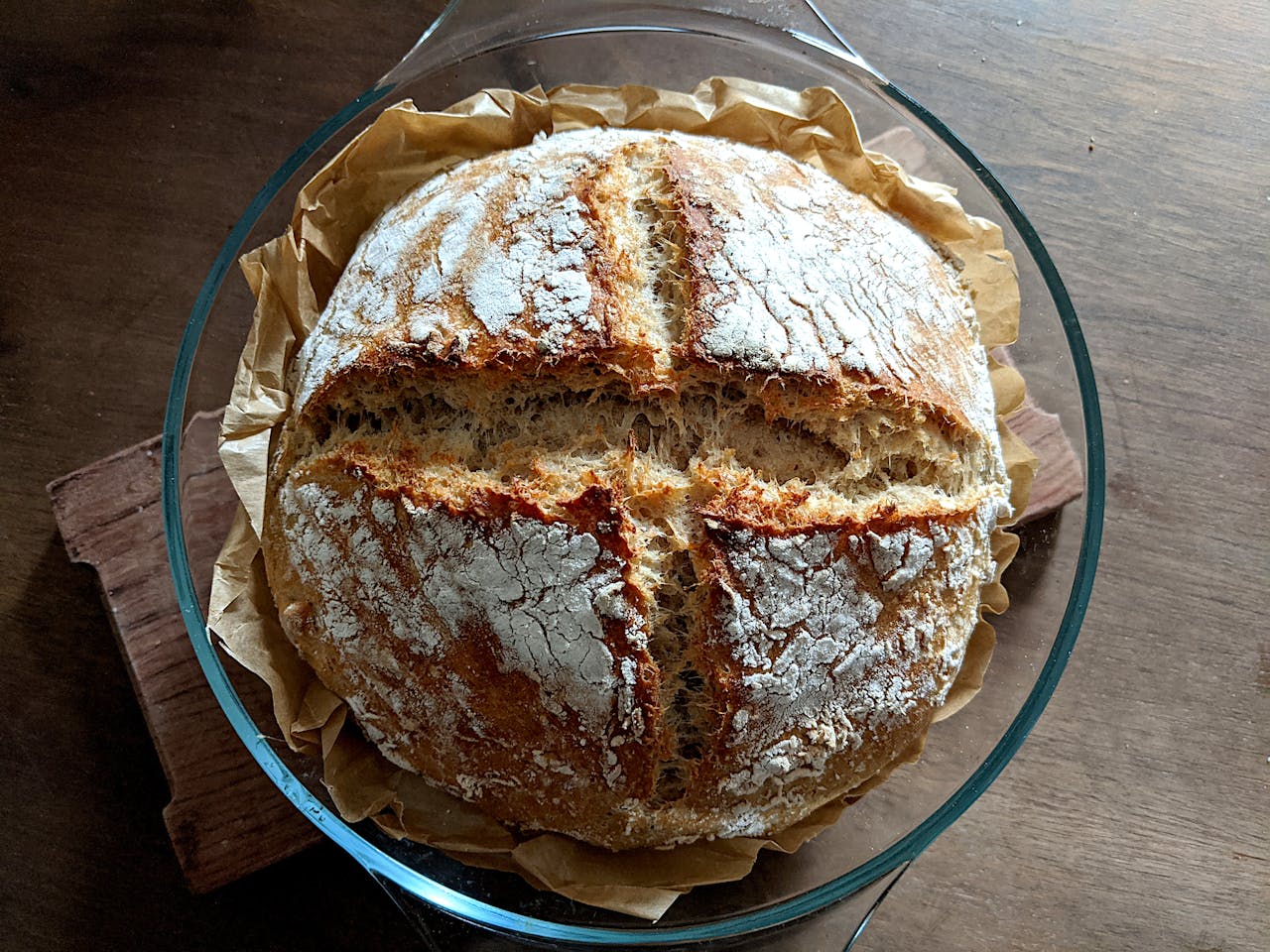 Top view of homemade crusty artisan bread in a glass bowl.